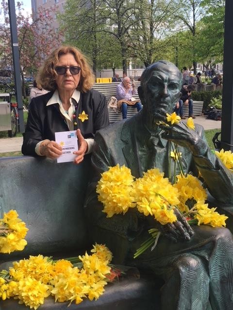 The President of Fundacja Edukacyjna Jana Karskiego, Ewa Junczyk-Ziomecka, pays tribute to Jan Karski and the fighters of the Warsaw Ghetto Uprising on its 75th anniversary. The Jan Karski bench is located next to the entrance to the POLIN Museum in Warsaw and to the monument commemorating the Warsaw Ghetto Uprising. (Photo: Archives of Fundacja Edukacyjna Jana Karskiego)